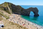 Durdle Door mit unzähligen Badegästen am Ärmelkanal.