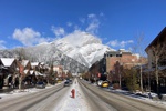Die Hauptstraße von Banff umgeben von schneebedeckten Bergen.