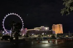 Nächtliches Riesenrad in Las Vegas mit Hotels im Hintergrund.